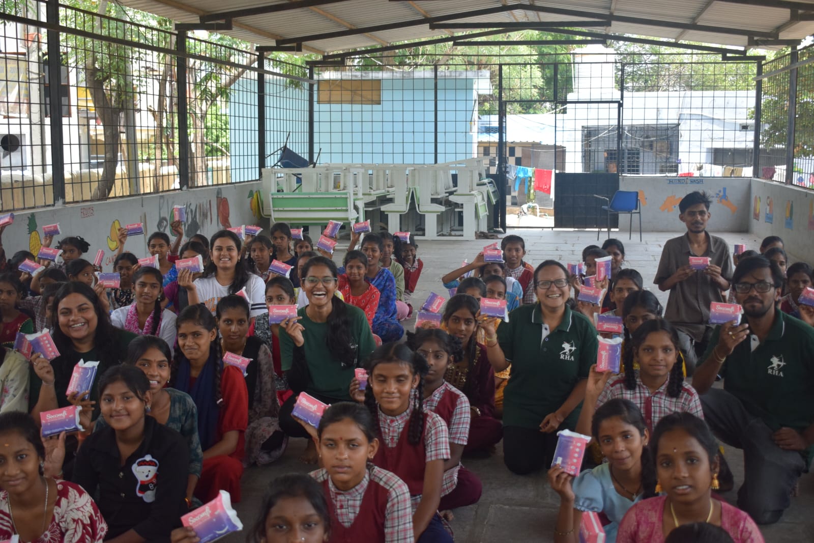 Students and volunteers holding up learning kits at Summer Camp